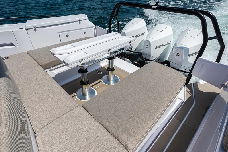 Slide: The Image of 2023 Axopar 45 Cross Cabin boat with cushioned seating and Mercury engines on the water. - 27