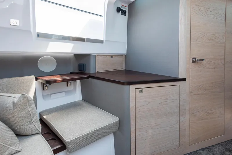 Slide: The Image of 2023 Axopar 45 Cross Cabin interior with modern seating and wooden cabinetry. - 33