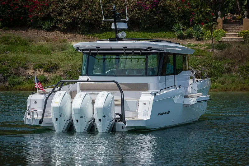 Slide: The Image of 2023 Axopar 45 Cross Cabin boat with triple engines on a calm waterway. - 5