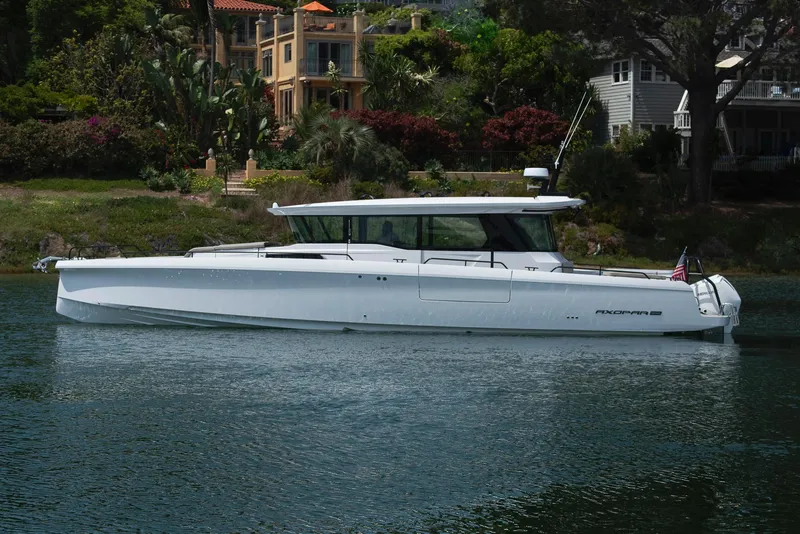 Slide: The Image of 2023 Axopar 45 Cross Cabin boat on a serene waterway, surrounded by lush greenery. - 6
