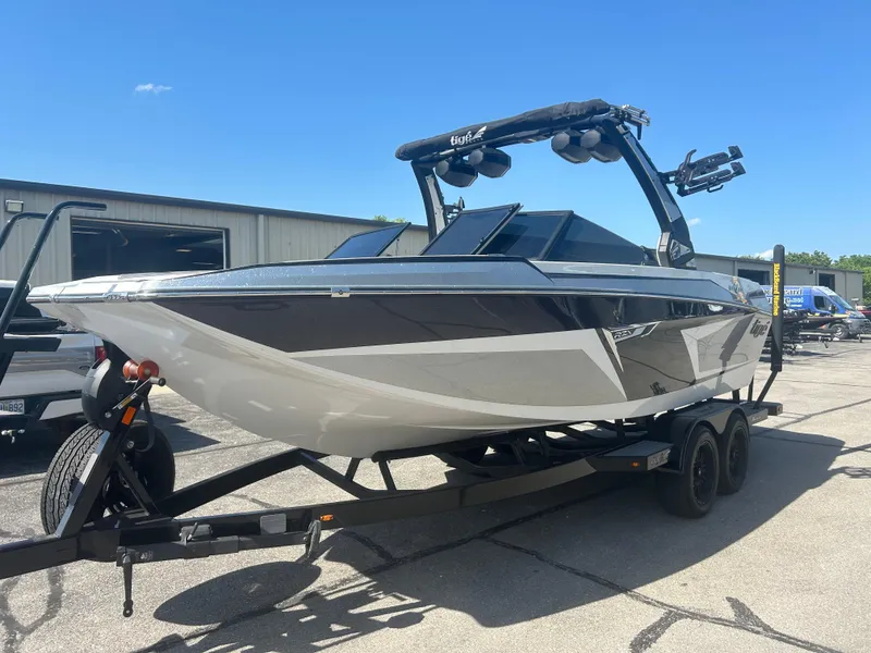 Slide: The Image of 2024 Tigé 22RZX boat on trailer, sleek design, black and white color scheme, sunny day. - 1