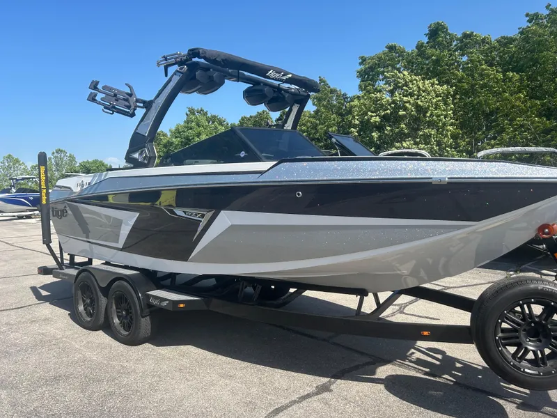 Slide: The Image of 2024 Tigé 22RZX boat on trailer, sleek design, parked outdoors. - 2