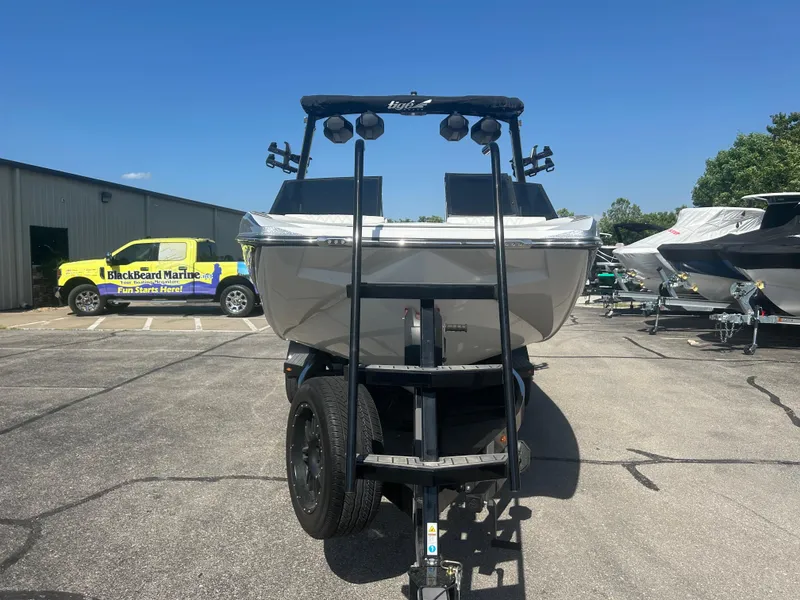 Slide: The Image of 2024 Tigé 22RZX boat on trailer in a marina parking lot. - 3