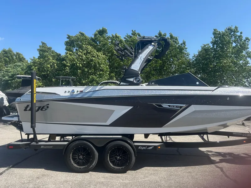 Slide: The Image of 2024 Tigé 22RZX boat on trailer, sleek design, parked outdoors. - 4