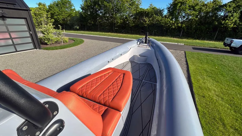 Slide: The Image of 2023 Fluid Watercraft M35 boat with red seating, parked outdoors. - 11