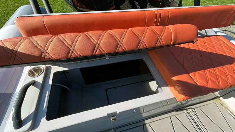 Slide: The Image of 2023 Fluid Watercraft M35 boat with orange diamond-stitched seating and storage compartment. - 14