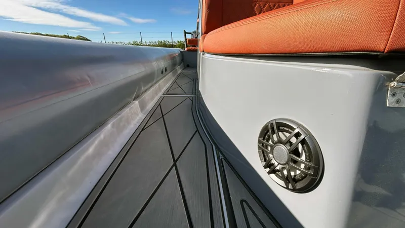 Slide: The Image of 2023 Fluid Watercraft M35 boat interior with orange seating and speaker detail. - 18