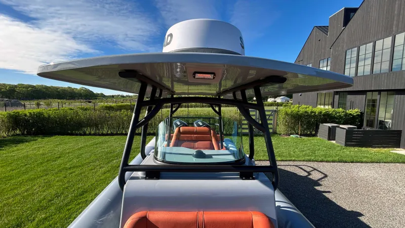 Slide: The Image of 2023 Fluid Watercraft M35 boat with sleek design, parked outdoors near modern building. - 19