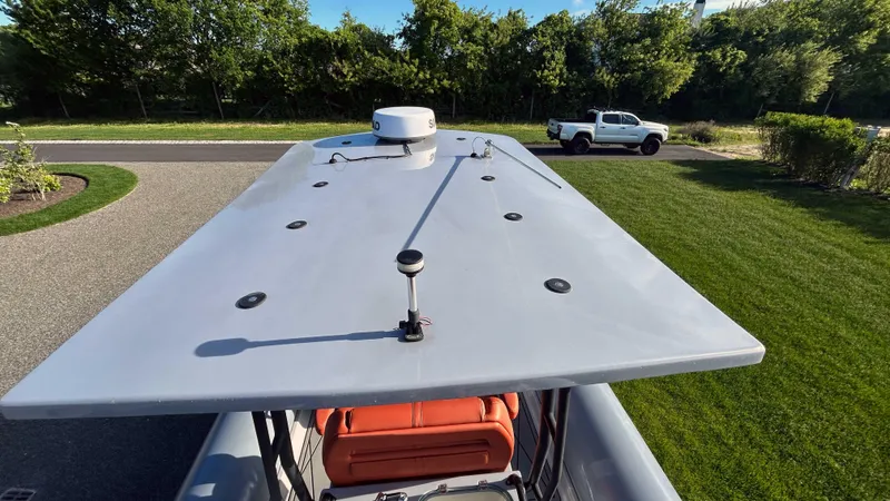 Slide: The Image of 2023 Fluid Watercraft M35 boat roof with radar, parked near a green lawn and white truck. - 20