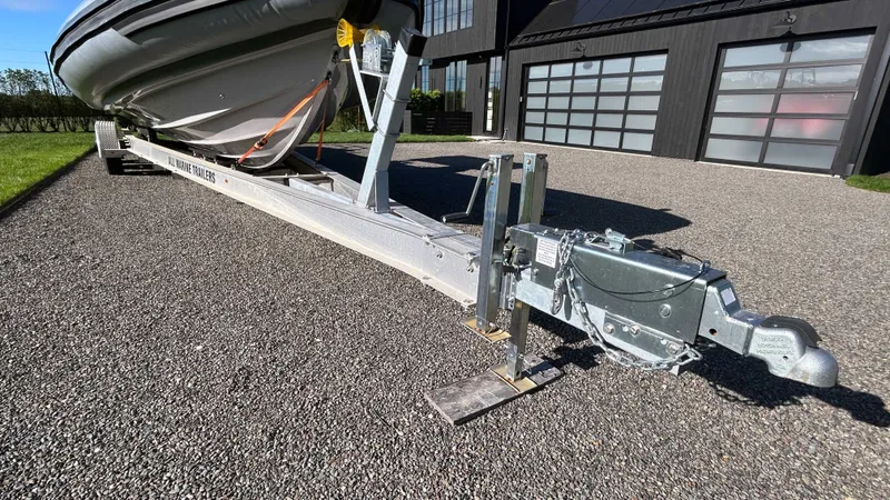 Slide: The Image of 2023 Fluid Watercraft M35 boat on trailer, parked on gravel driveway. - 24