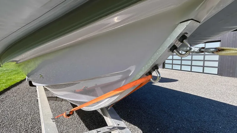 Slide: The Image of 2023 Fluid Watercraft M35 boat hull secured with orange strap on trailer. - 25