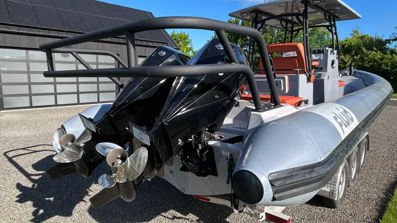 Slide: The Image of 2023 Fluid Watercraft M35 boat with dual outboard motors, docked outdoors. - 26