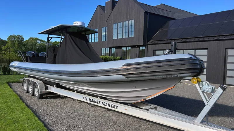 Slide: The Image of 2023 Fluid Watercraft M35 boat on trailer, parked near modern building. - 31