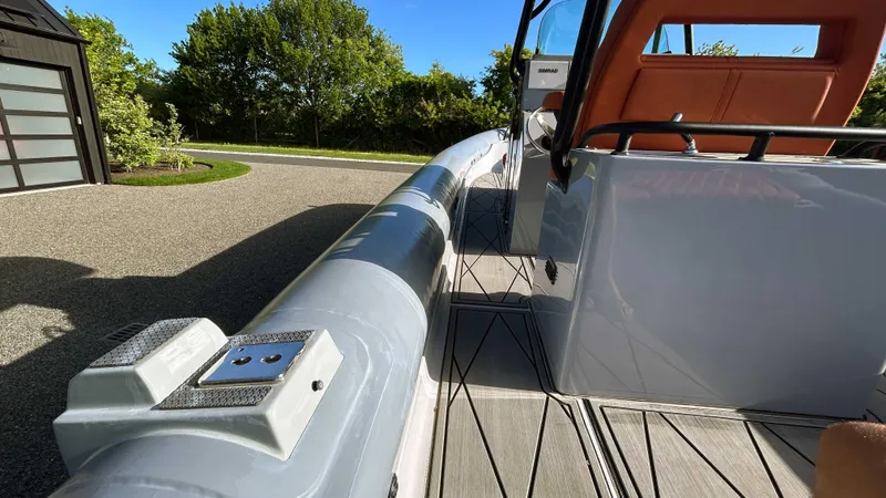Slide: The Image of 2023 Fluid Watercraft M35 boat, sleek design, docked outdoors on a sunny day. - 6