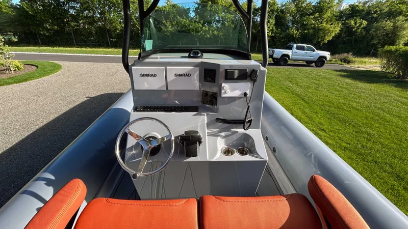 Slide: The Image of 2023 Fluid Watercraft M35 boat with orange seats and modern dashboard, parked on a driveway. - 8