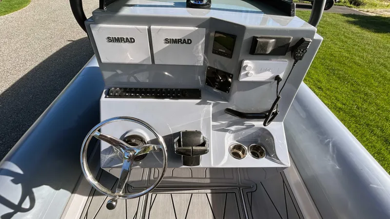 Slide: The Image of 2023 Fluid Watercraft M35 boat dashboard with steering wheel and Simrad electronics. - 9