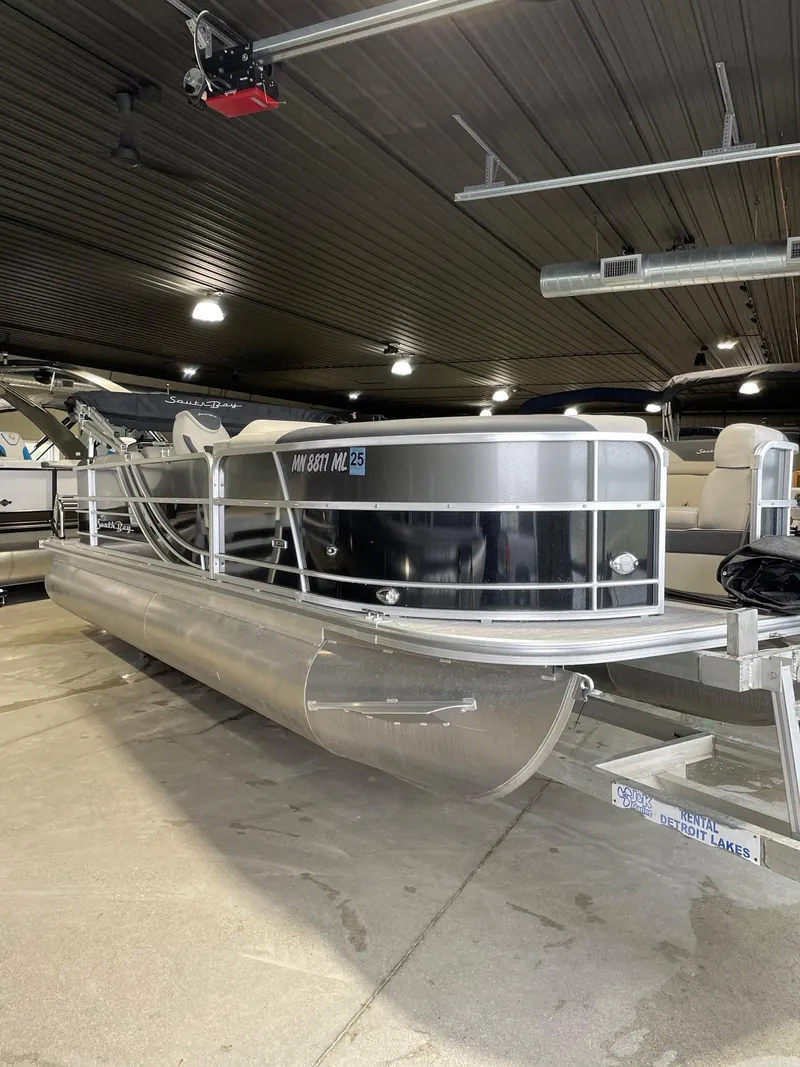 Slide: The Image of 2023 South Bay 224RS LE pontoon boat in a showroom setting. - 1