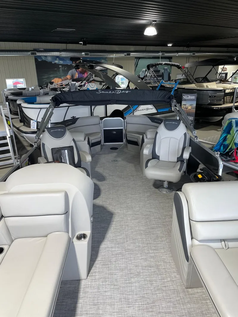 Slide: The Image of 2023 South Bay 224RS LE pontoon boat interior with modern seating in showroom. - 3