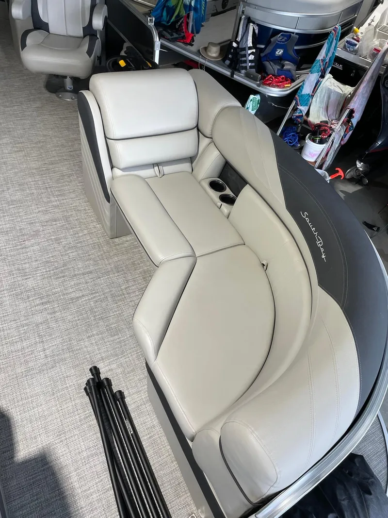 Slide: The Image of 2023 South Bay 224RS LE boat interior with gray seating and cup holders. - 4