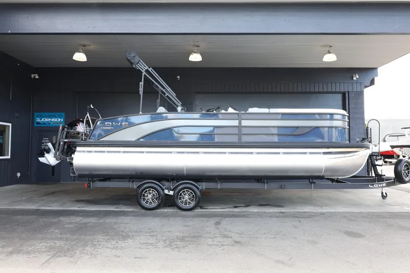 Slide: The Image of 2025 Lowe SS 230 DL pontoon boat on trailer in showroom. - 1