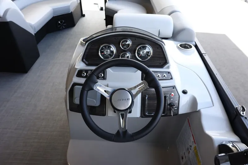 Slide: The Image of 2025 Lowe SS 230 DL boat dashboard with steering wheel and gauges. - 14