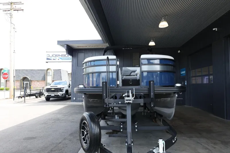 Slide: The Image of 2025 Lowe SS 230 DL pontoon boat on trailer outside dealership. - 3