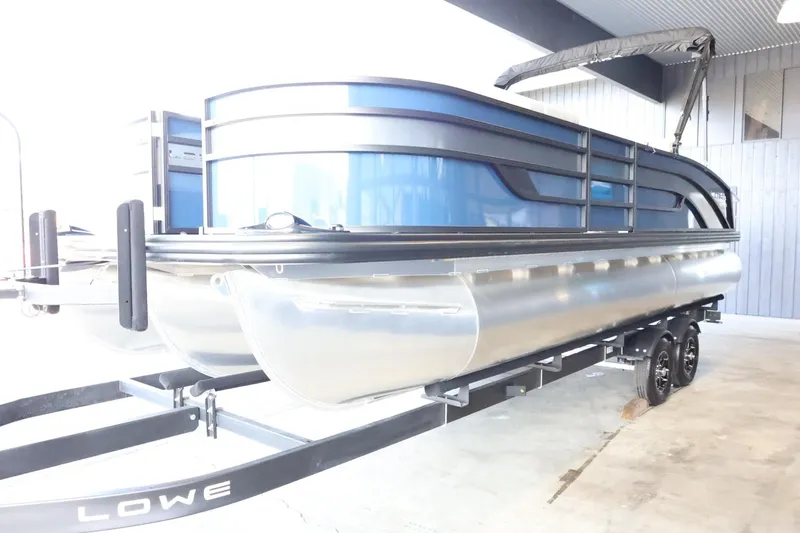 Slide: The Image of 2025 Lowe SS 230 DL pontoon boat on trailer in a covered area. - 4