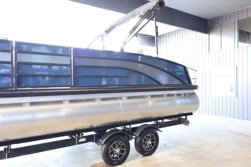 Slide: The Image of 2025 Lowe SS 230 DL pontoon boat on trailer in a covered area. - 5