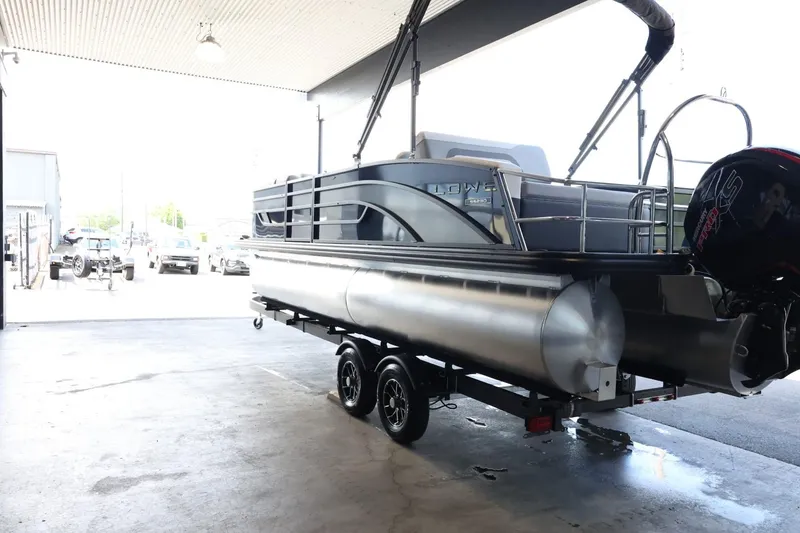 Slide: The Image of 2025 Lowe SS 230 DL pontoon boat on trailer in a covered area. - 6
