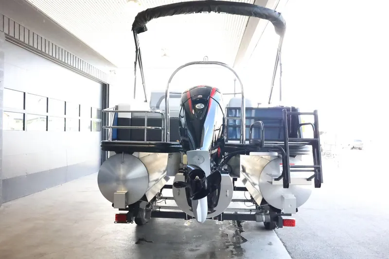 Slide: The Image of 2025 Lowe SS 230 DL pontoon boat with outboard motor in a covered area. - 7