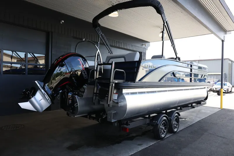 Slide: The Image of 2025 Lowe SS 230 DL pontoon boat on trailer, under covered area. - 8