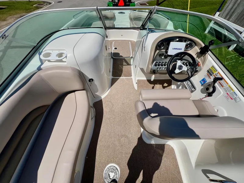 Slide: The Image of 2013 Hurricane SunDeck 217 OB boat interior with beige seating and steering console. - 10