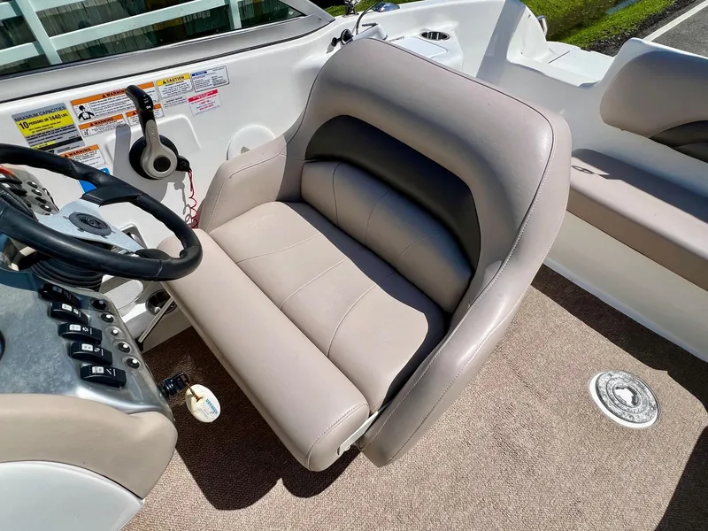 Slide: The Image of Captain's seat on 2013 Hurricane SunDeck 217 OB boat, featuring beige and black upholstery. - 11