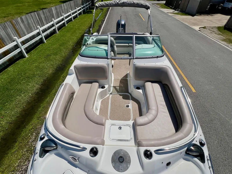 Slide: The Image of 2013 Hurricane SunDeck 217 OB boat with spacious seating and sleek design on a road. - 17