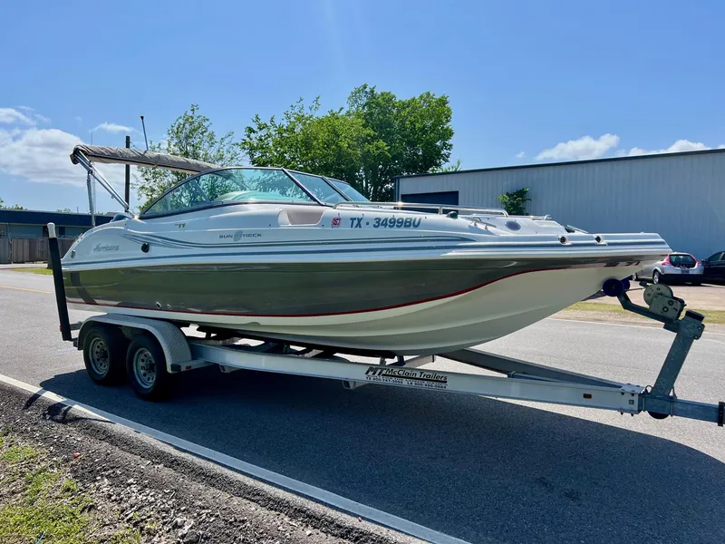 Slide: The Image of 2013 Hurricane SunDeck 217 OB boat on trailer, parked outdoors under clear blue sky. - 5