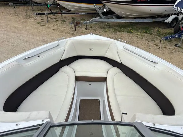 Slide: The Image of 2018 Cobalt 220S boat interior with white and brown seating, parked on a trailer. - 13