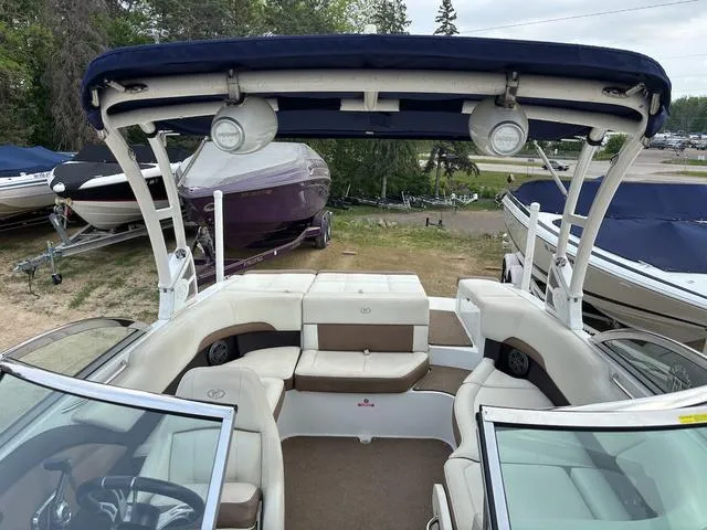 Slide: The Image of 2018 Cobalt 220S boat interior with seating, canopy, and surrounding boats in a marina setting. - 14
