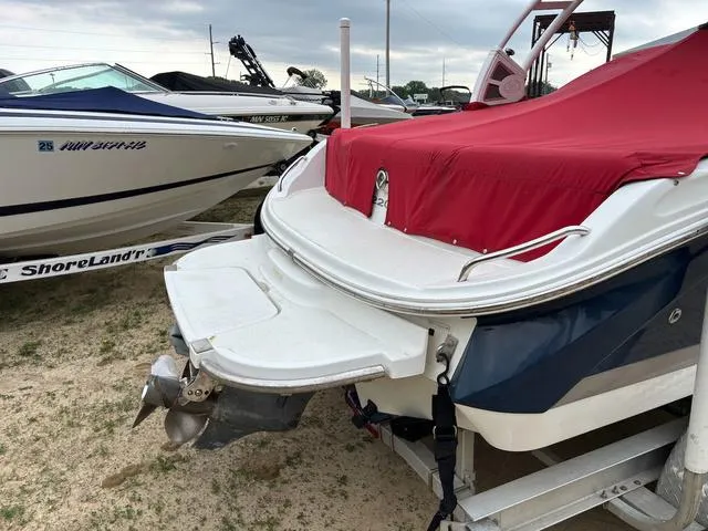 Slide: The Image of 2018 Cobalt 220S boat with red cover, parked on a trailer, next to another boat. - 5