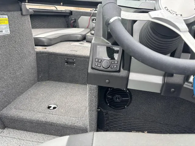 Slide: The Image of Interior of a 2022 Lund 1975 Tyee Sport boat, featuring steering and control panel. - 10