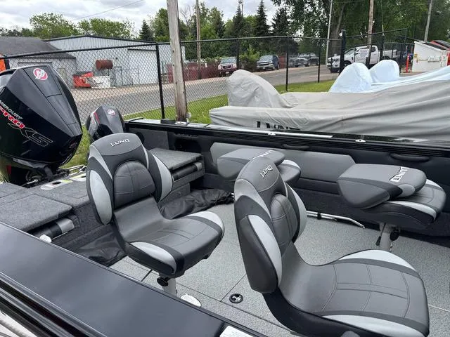 Slide: The Image of 2022 Lund 1975 Tyee Sport boat interior with gray seating and powerful outboard motor. - 11