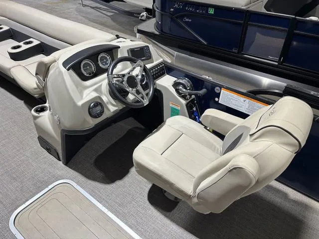 Slide: The Image of Captain's helm of 2021 Barletta C24UC pontoon boat with beige seating and control panel. - 6