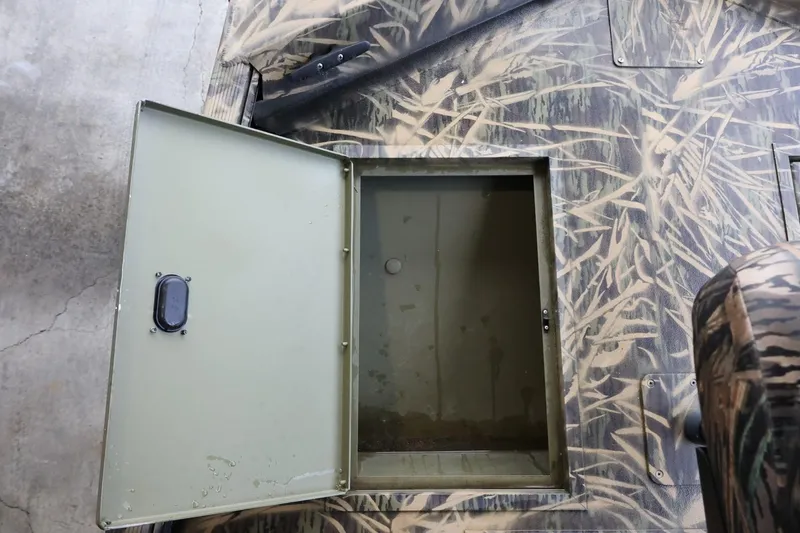 Slide: The Image of Open storage compartment on 2023 Lowe Roughneck 1760 Pathfinder boat with camouflage design. - 15