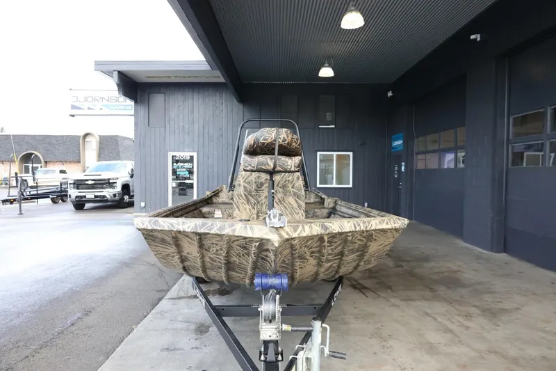 Slide: The Image of 2023 Lowe Roughneck 1760 Pathfinder boat on trailer, parked under a covered area. - 3