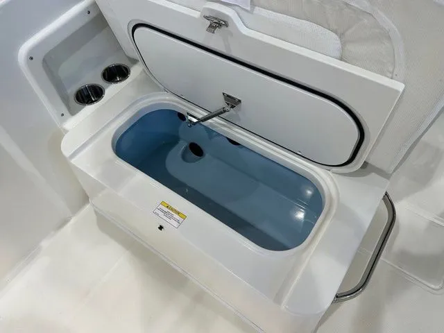 Slide: The Image of 2025 Boston Whaler 210 Vantage boat livewell with open lid and cup holders. - 10