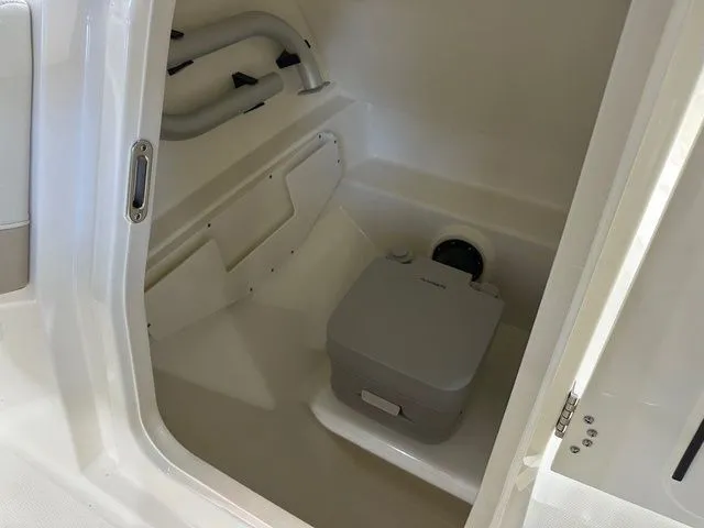 Slide: The Image of Interior of 2025 Boston Whaler 210 Vantage boat with compact marine toilet. - 5