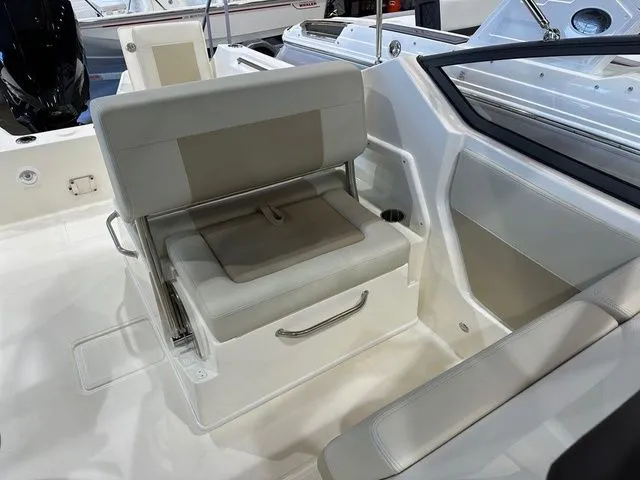 Slide: The Image of 2025 Boston Whaler 210 Vantage boat interior with cushioned seating and storage. - 6
