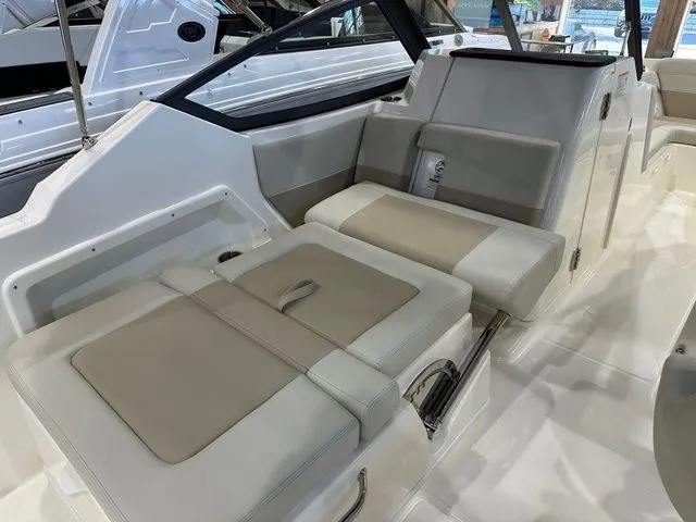 Slide: The Image of 2025 Boston Whaler 210 Vantage interior seating, featuring beige and gray cushioned seats. - 9