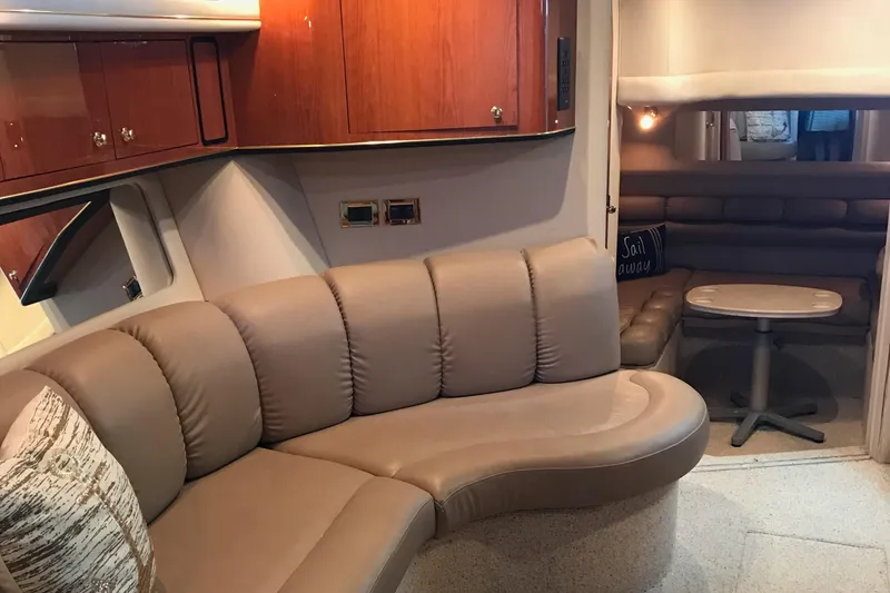 Slide: The Image of 1998 Sea Ray 400 Sundancer interior with curved leather seating and wooden cabinetry. - 5