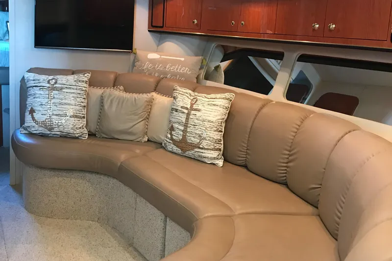 Slide: The Image of Interior of 1998 Sea Ray 400 Sundancer with beige leather seating and nautical-themed pillows. - 6
