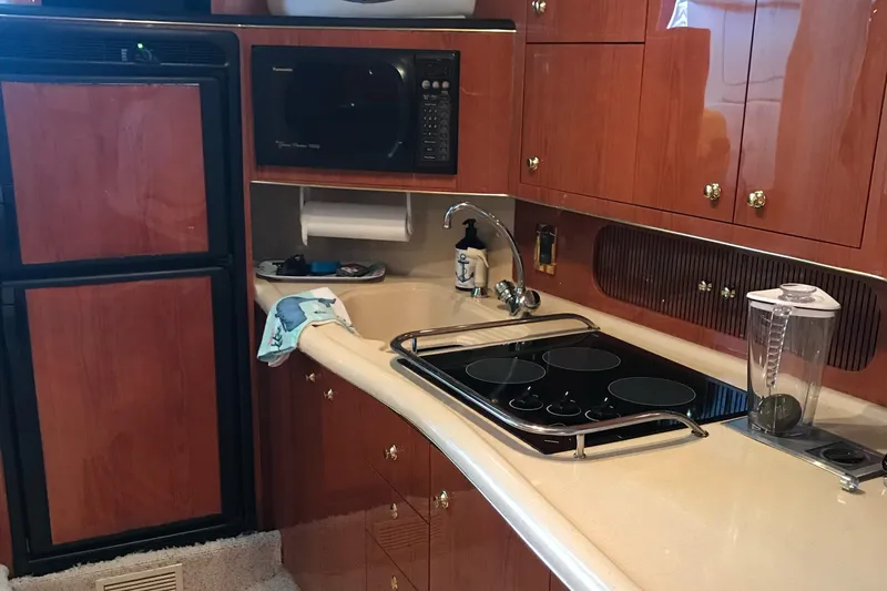 Slide: The Image of 1998 Sea Ray 400 Sundancer yacht kitchen with stove, microwave, and fridge. - 8